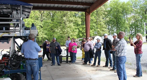 A University of Arkansas extension agent shows the students their plot planter and how it works to test seed varieties, fertilizer applications, seed depth, etc.